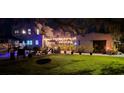Landscaped backyard featuring a lush lawn, string lights, and cozy seating, ideal for outdoor gatherings and relaxation at 6251 4Th S Ave, St Petersburg, FL 33707