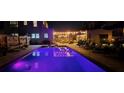 A refreshing pool at night is surrounded by lounge chairs and a hammock, perfect for relaxing and entertaining at 6251 4Th S Ave, St Petersburg, FL 33707