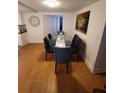 Dining room with hardwood floors, a glass dining table with six chairs, and art on the wall at 6318 Ridge Crest Dr, Port Richey, FL 34668
