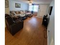 Inviting living room featuring hardwood floors, a comfortable seating area, and plenty of natural light at 6318 Ridge Crest Dr, Port Richey, FL 34668