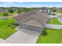 Aerial view showcasing the home's well-maintained landscaping and spacious three-car driveway at 6670 Paden Wheel St, Zephyrhills, FL 33541