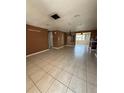 Open concept living room with tile flooring leading to the dining area and kitchen at 7021 Mayfield Dr, Port Richey, FL 34668