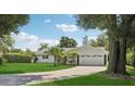 Well maintained single-story home with a lush green lawn and mature tropical landscaping at 71 Flamingo Cir, Safety Harbor, FL 34695