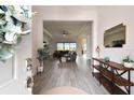 Welcoming foyer with wood-look tile flooring and an open view to living area at 8192 Ivy Stark Blvd, Wesley Chapel, FL 33545