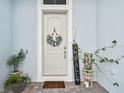 Inviting front door with decorative wreath and potted plants at 8192 Ivy Stark Blvd, Wesley Chapel, FL 33545