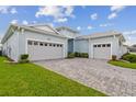 Spacious three-car garage with paved driveway and lush landscaping at 8192 Ivy Stark Blvd, Wesley Chapel, FL 33545