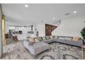 Bright and airy open-concept living room with an expansive sectional sofa that leads into a modern kitchen at 12650 Shetland Walk Dr, Lithia, FL 33547