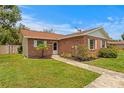 Cozy brick home with tidy landscaping, featuring white-trimmed windows and walkway at 13046 Leverington St, Tampa, FL 33624