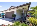 Exterior view showcasing the home's architectural details, including a two-car garage and meticulously landscaped front yard at 13168 84Th Ter, Seminole, FL 33776