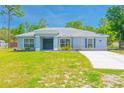 Charming one-story home featuring a well-manicured lawn and a long driveway leading to the welcoming entrance at 15207 Taralane Ave, Brooksville, FL 34604