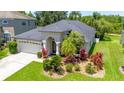 A well-maintained single-story home with a lush, landscaped front yard and a two car garage at 19412 Heritage Harbor, Lutz, FL 33558