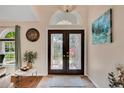 Inviting foyer featuring decorative glass double doors and travertine flooring at 19412 Heritage Harbor, Lutz, FL 33558