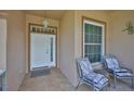 Welcoming front porch featuring tile flooring, chairs, and a storm door at 2316 Lyndhurst Dr, Sun City Center, FL 33573