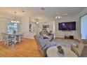 Open-concept living room featuring hardwood floors, a ceiling fan, and a view into the dining area at 2316 Lyndhurst Dr, Sun City Center, FL 33573