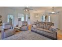 Bright and airy living room with hardwood floors, ceiling fan, and comfortable seating at 2316 Lyndhurst Dr, Sun City Center, FL 33573