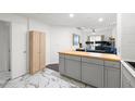 Kitchen featuring gray cabinets, butcher block island, marble flooring, and opening to the living room at 2410 W Azeele St # 214, Tampa, FL 33609