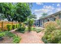 Beautiful backyard featuring lush landscaping, brick paths and screened patio at 2484 Whitman St, Clearwater, FL 33765