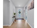 Inviting foyer with decorative console table, attractive front door, and light wood flooring at 2781 Dolores Home Ave, Valrico, FL 33594