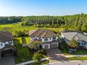 Aerial view of a luxurious home with a tile roof, backing to a private green space at 28512 Picana Ln, Wesley Chapel, FL 33543