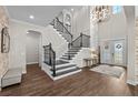 Grand foyer with soaring ceilings, wood floors, elegant staircase and beautiful lighting at 28512 Picana Ln, Wesley Chapel, FL 33543