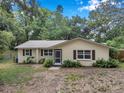 Well-kept one-story home with shutters, front garden and established trees at 316 Jenkins Ave, Brooksville, FL 34604