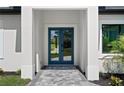 Front entrance with gray stone tile walkway and bright blue double doors framed by white columns at 3344 Lagoy St, North Port, FL 34291