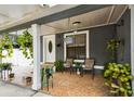 Inviting front porch with neutral tiling, hanging plants, and comfortable seating creates a cozy outdoor space at 3414 Whittier St, Tampa, FL 33619
