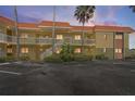 Charming two-story condo building with a red tile roof, large palm trees, and well-maintained landscaping at 4103 Gulf Blvd # 210, St Pete Beach, FL 33706