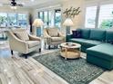 Bright living room featuring a comfortable sofa, stylish chairs, and a decorative rug on hardwood flooring at 4103 Gulf Blvd # 210, St Pete Beach, FL 33706