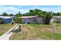 Charming single-story home with a front lawn, mature trees, and a one-car garage, offering a cozy curb appeal at 4709 Mineola St, Bradenton, FL 34207