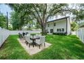 Expansive backyard with lush lawn, a concrete patio, and an outdoor dining area at 4710 W Tambay Ave, Tampa, FL 33611