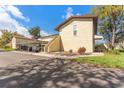 Building exterior showcasing covered parking spaces, stairs leading to units, and well-kept landscaping at 501 E Bay Dr # 102, Largo, FL 33770