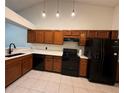 Traditional-style kitchen with ample wood cabinetry, sleek black appliances, and elegant tile flooring at 5804 Red Cedar Ln # 5804, Tampa, FL 33625