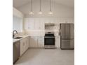 Modern kitchen featuring white cabinetry, stainless steel appliances, marble backsplash, and ample counter space at 5804 Red Cedar Ln # 5804, Tampa, FL 33625