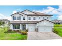 Beautiful two-story home showcasing a well-manicured lawn, a two-car garage, and a welcoming entrance at 7628 Surf Reed Way, Wesley Chapel, FL 33545