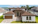 Charming home boasting a manicured lawn, a paver driveway, and a grand entrance at 8834 Sanders Tree Loop, Wesley Chapel, FL 33545