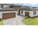 Spacious three car garage with paver driveway, ideal for car enthusiasts or extra storage space at 8834 Sanders Tree Loop, Wesley Chapel, FL 33545