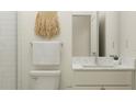 Stylish bathroom with a modern vanity, toilet, and a decorative wall hanging enhancing the space's aesthetic at 9456 Gladsome Dr, Land O Lakes, FL 34637
