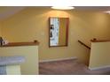 Inviting entryway featuring carpeted stairs, a mirror, and light yellow walls leading to a peek of the kitchen at 9722 Indian Key Trl # 116, Seminole, FL 33776