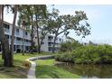 Multi-Gathering home exterior with green space, mature trees, and a sidewalk along the water at 9722 Indian Key Trl # 116, Seminole, FL 33776