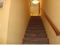 Carpeted staircase features a wooden handrail and leads to the upper level of the home at 9722 Indian Key Trl # 116, Seminole, FL 33776
