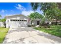 Well-maintained home with a two-car garage, a large driveway, and lush landscaping at 10513 Carrollview Dr, Tampa, FL 33618