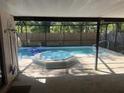 Relaxing screened-in pool area featuring a refreshing pool and hot tub, perfect for outdoor enjoyment at 10811 Candlin Ct, Riverview, FL 33578