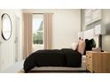Comfortable bedroom featuring large window, neutral tones, and a stylish black comforter at 10826 Keato Beach Ct, Tampa, FL 33647