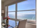 Dining area featuring a modern glass table and chairs with a stunning ocean backdrop at 1270 Gulf Blvd # 1901, Clearwater Beach, FL 33767