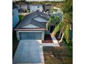 Well-maintained single-Gathering home showcasing a two-car garage, driveway, and mature palm trees at 12720 Hampton Hill Dr, Riverview, FL 33578