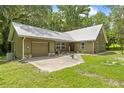 A well-kept home with a freshly mowed lawn and eye-catching silver metal roof at 1562 Oakhurst Dr, Brooksville, FL 34601