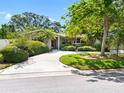 Charming home with a circular driveway framed by mature trees and manicured landscaping at 1701 38Th N St, St Petersburg, FL 33713