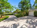 Home featuring a spacious driveway leading to a garage, set among trees and greenery at 1701 38Th N St, St Petersburg, FL 33713