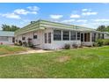 Charming home exterior with a bright green roof and lovely enclosed porch at 1802 Bedford Ln # 7, Sun City Center, FL 33573